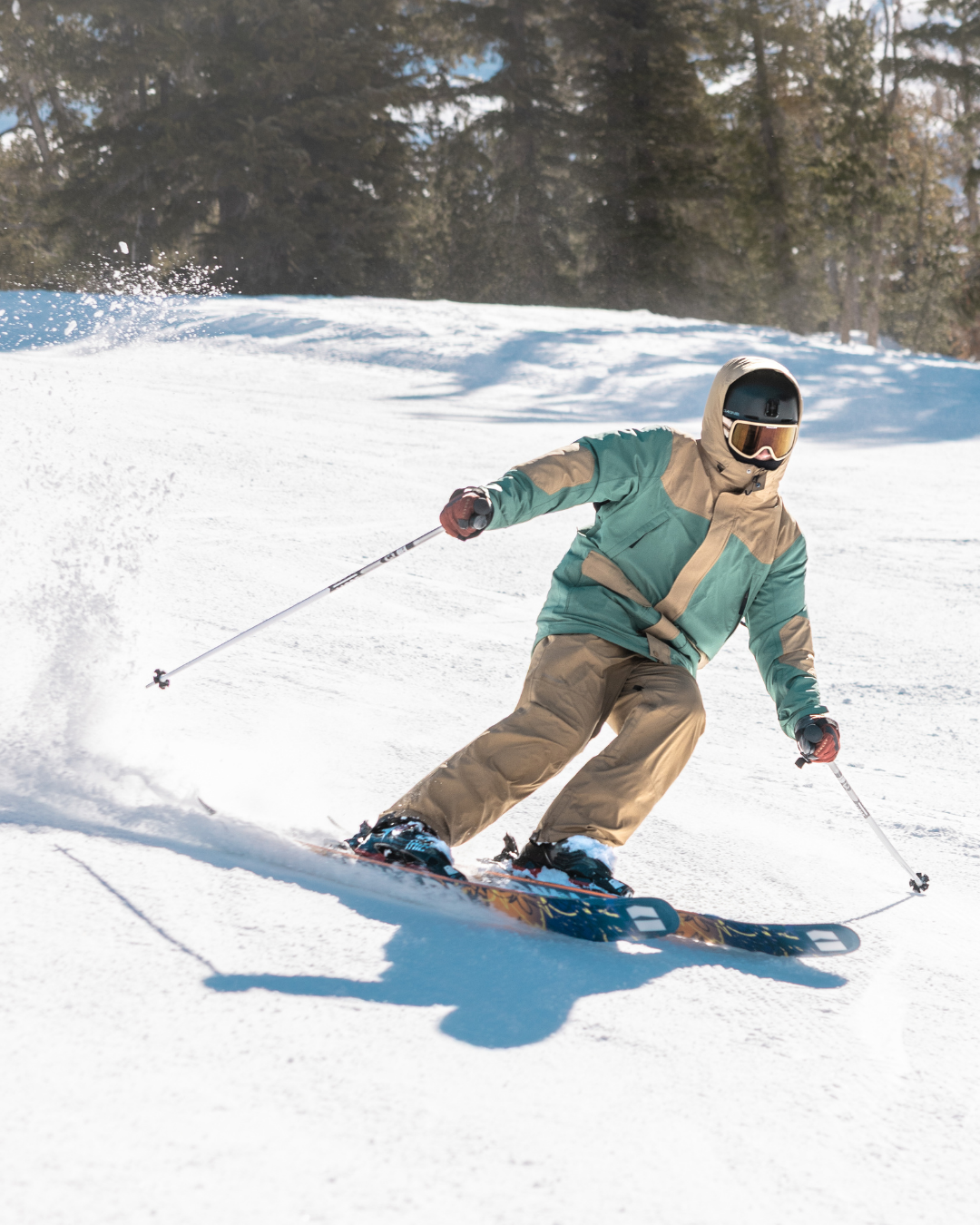 Person skiing down a snowy slope with trees in the background